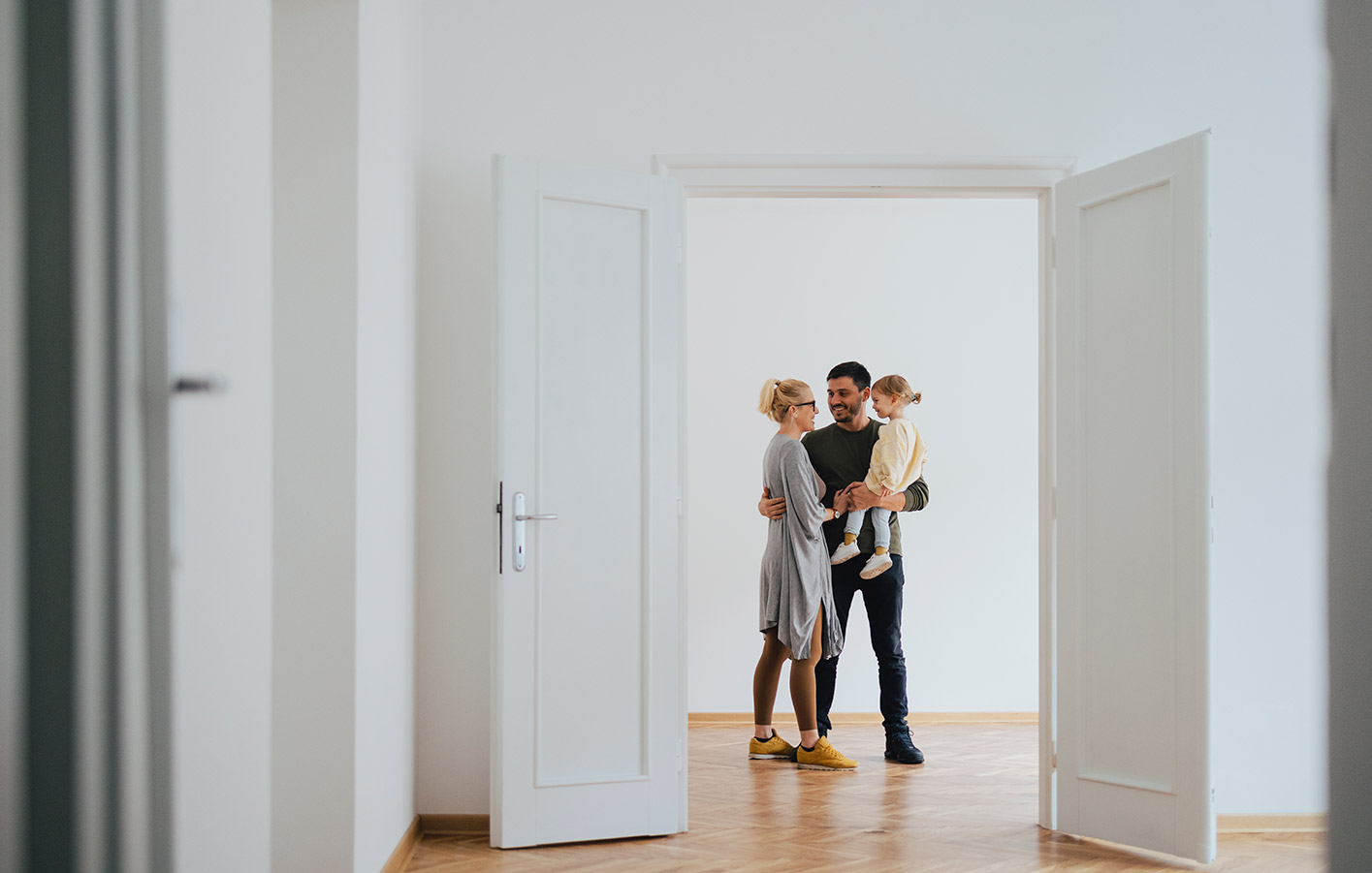 Fürs perfekte Glück im neuen Zuhause - die passenden Innentüren Blick durch geöffnet Innentür auf junge Familie