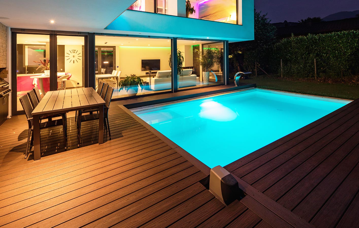 Die eigene Terrasse im Garten mit großem Pool eine große einladende Terrasse mit einem Pool im Dunkeln - beleuchtet